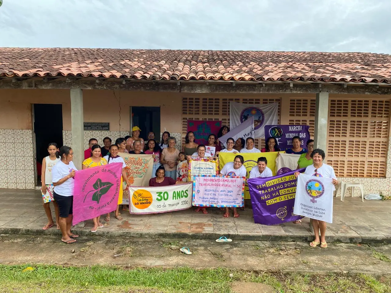 Foto de mulheres do MMTR-SE com faixas e bandeiras pelos 30 anos e a Marcha Mundial